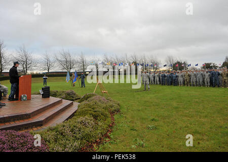 Stati Uniti Navy Capt. Daryl Hancock, estrema sinistra, comando marittimo, RAF Northwood senior nazionale rappresentante degli Stati Uniti, risolve la folla durante la 74a Pearl Harbor Cerimonia di commemorazione a RAF Molesworth, Regno Unito, 7 dicembre, 2015. In aggiunta all'oratore ospite, la cerimonia comprendeva una tre-volley salutate dalla 423rd Guardia d'onore e una formazione salutate come la 48th Fighter Wing F-15 Eagle piloti ha effettuato un volo. (U.S. Air Force photo by Staff Sgt. Ashley Tyler/rilasciato) Foto Stock