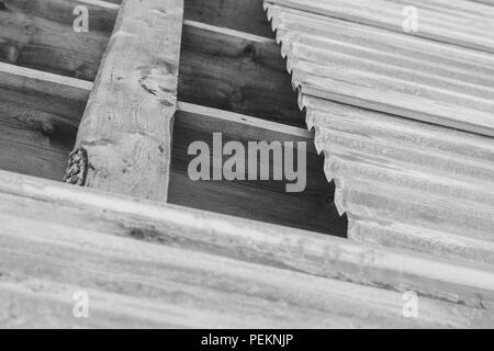 Il tetto di ferro sul tetto incompiuto di una gabbia in legno Foto Stock