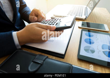 Imprenditori calcolare il reddito da attività di esportazione sul tavolo in legno.La concezione di business. Foto Stock