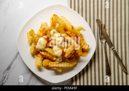 Canadian Poutine crinkle-tagliare le patatine fritte con il sugo di carne e il formaggio Foto Stock