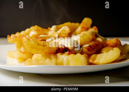 Canadian Poutine crinkle-tagliare le patatine fritte con il sugo di carne e il formaggio Foto Stock