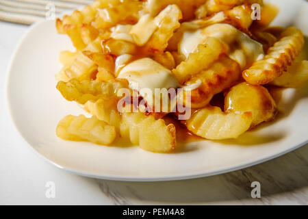 Canadian Poutine crinkle-tagliare le patatine fritte con il sugo di carne e il formaggio Foto Stock