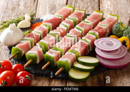 Per barbecue materie shish kebab con pepe e lo strutto su spiedini di close-up e ingredienti, verdure, spezie, erbe sul tavolo orizzontale. Foto Stock