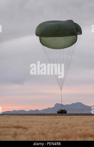 Un Humvee cade a terra da paracadute durante la consegna dell'antenna e il recupero della formazione a Fort Huachuca, Ariz., Dicembre 9, 2015. L'Humvee è stato fatto cadere da un'U.S. Air Force HC-130J contro il re II dalla 79th Rescue Squadron di stanza a Davis-Monthan Air Force Base. (U.S. Air Force foto di Senior Airman Chris Massey/rilasciato) Foto Stock