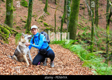 Donna con un cane in legno di faggio. Foto Stock