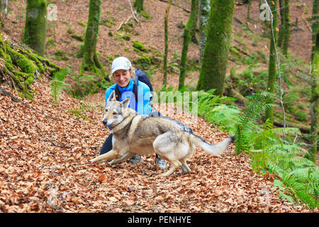 Donna con un cane in legno di faggio. Foto Stock