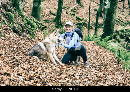 Donna con un cane in legno di faggio. Foto Stock