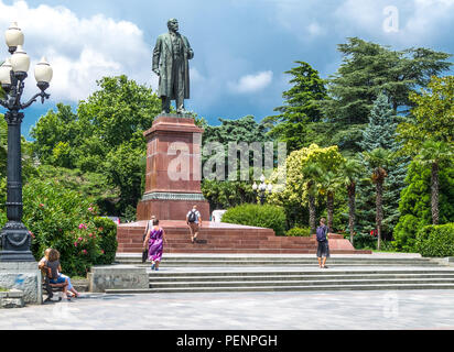 Jalta, Ucraina - Agosto 16, 2012: persone locali sotto il monumento di Lenin nel parco Nekrasoy Foto Stock