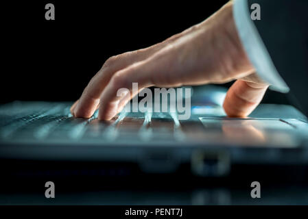 Chiudere fino a basso angolo di visione delle mani di un uomo d affari con immissione di dati sul suo computer portatile o la navigazione sul web Foto Stock