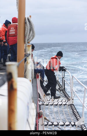 Membri del guardacoste Stella Polare ponte inferiore dipartimento reti di sicurezza sulla fresa del ponte di volo mentre in corso nell'Oceano del Sud Gen 3, 2016. L'equipaggio ha abbassato le reti in preparazione per un unmanned aviation system test di volo dall'attività rompighiaccio. (U.S. Coast Guard foto di Sottufficiali di 2a classe di concedere DeVuyst) Foto Stock