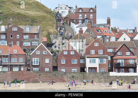 I turisti a Whitby su i passi fino alla chiesa di Santa Maria e poi Whitby Abbey sul lato est del porto, North Yorkshire, Inghilterra, Regno Unito. Foto Stock