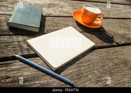 Caffè, matita, notebook e il pezzo di carta a trama su un tavolo di legno. Foto Stock