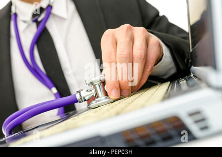 Close up repairman tenendo lo stetoscopio sul suo vecchio computer portatile tastiera. Foto Stock