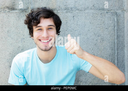 Giovani caucasici uomo adulto con gli occhi blu che mostra il pollice fino all aperto con spazio di copia Foto Stock