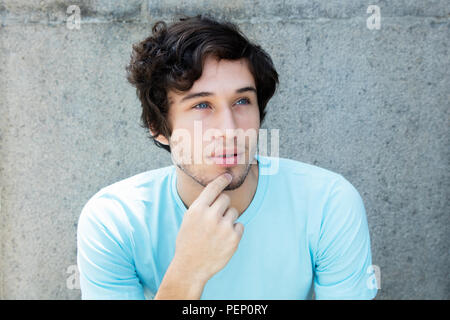 Pensando giovani caucasici uomo adulto con gli occhi blu all'aperto con spazio di copia Foto Stock