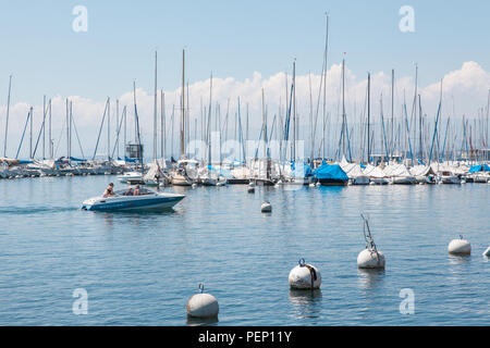 Motore privato barca ritorna a Lausanne Ouchy port, Svizzera sul Lago Lemano (Lago di Ginevra) su soleggiate giornate estive Foto Stock