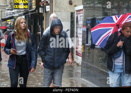 Piccadilly Circus. Londra. 16 ago 2018. Regno Unito: Meteo - turisti riparo dalla pioggia sotto gli ombrelloni durante piogge abbondanti nella capitale. Credito: Dinendra Haria/Alamy Live News Foto Stock