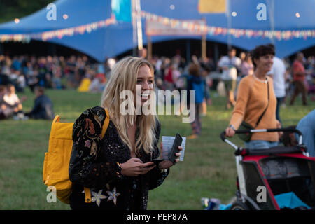 Glanusk Park, Brecon, Galles, 16 agosto 2018. La prima sera del festival musicale Green Man nelle Brecon Beacons Mountains in Galles. Il sito è aperto il giorno prima del festival vero e proprio. Foto: Persone che si rilassano con le birre fuori dal far Out Stage. Crediti: Rob Watkins/Alamy Live News Foto Stock