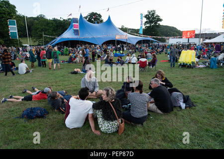 Glanusk Park, Brecon, Galles, 16 agosto 2018. La prima sera del festival musicale Green Man nelle Brecon Beacons Mountains in Galles. Il sito è aperto il giorno prima del festival vero e proprio. Immagini: Persone che si rilassano all'esterno sull'erba fuori dal far Out Stage. Crediti: Rob Watkins/Alamy Live News Foto Stock