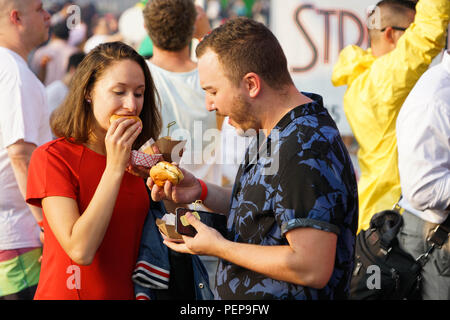 New York, Stati Uniti d'America. 16 Ago, 2018. Un paio mangiare hamburger in Time Out New York la battaglia del Burger 2018 in New York, Stati Uniti, su agosto 16, 2018. Oltre 100 persone hanno assistito a questo evento il giovedì per gusto e preferiti per il loro voto hamburger da Burger fornitori attraverso la città. Credito: Lin Bilin/Xinhua/Alamy Live News Foto Stock