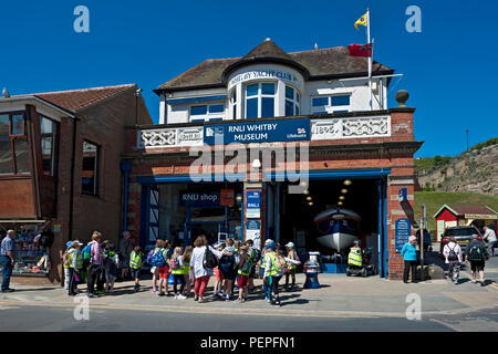 Persone turisti visitatori al di fuori della stazione e museo Old RNLI Lifeboat in estate Whitby North Yorkshire Inghilterra Regno Unito GB Gran Bretagna Foto Stock