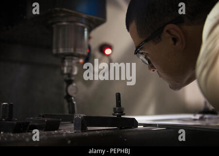 Il personale addetto alla manutenzione dell'aviazione del 455th Expeditionary Maintenance Squadron Fabrication Flight gestisce una macchina CNC presso l'aeroporto di Bagram, Afghanistan, per tagliare il metallo per componenti complessi di aeromobili. Il processo di controllo numerico computerizzato consente la fabbricazione di parti non possibili con metodi tradizionali, supportando la manutenzione degli aeromobili e la preparazione operativa per le missioni dell'aeronautica militare nell'ambito dei programmi Sentinel e Resolute Support dell'operazione Freedom. Foto Stock