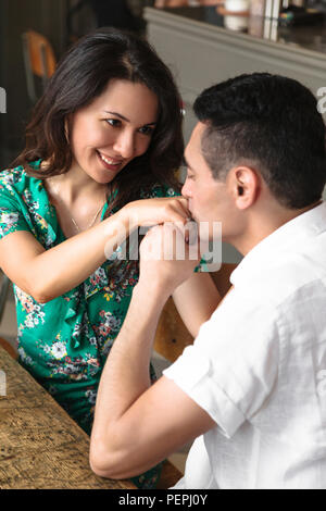 Marito baci delicatamente la sua bella moglie per la mano Foto Stock