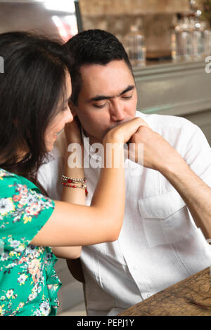 Attraente uomo baci delicatamente la mano di sua moglie Foto Stock