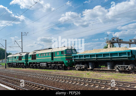 Locomotiva Diesel sulla stazione con vetture di carico Foto Stock