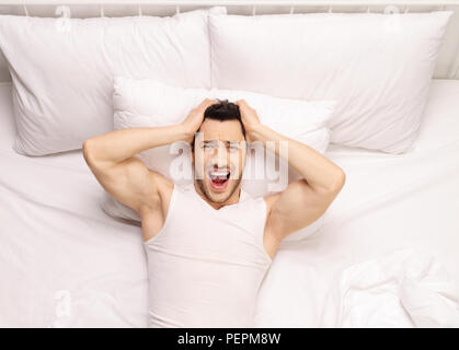 Frustrati giovane uomo disteso a letto Foto Stock