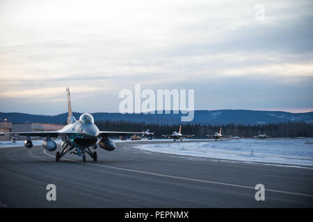 Stati Uniti Air Force F-16 Fighting Falcon aeromobili con la XVIII Aggressor Squadron taxi per la linea di volo a Eielson Air Force Base in Alaska, poco dopo l'alba Gen 24, 2016 in transito a Kadena Air Base, il Giappone per partecipare a esercizi di addestramento. Più di 150 i manutentori da 354Fighter Wing manterrà gli aggressori in aria e preparare U.S. Avieri, marinai e marines per operazioni di emergenza lungo con i partner della coalizione nel teatro del Pacifico. (U.S. Air Force photo by Staff Sgt. Shawn nichel/rilasciato) Foto Stock