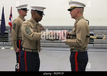 Sgt. Il Mag. Spencer J. Beacham (centro), in uscita arruolati senior leader del Marine Corps stazione di reclutamento di Orange County, restituisce la spada di office per il Mag. James Dollard, il suo comandante, durante un sollievo e nomina cerimonia in Seal Beach, Caif., Gen 15, 2016. Durante la cerimonia, Beacham, da Dothan, Ala, è stato premiato con un servizio meritevole medaglia e rinunciato a dazi a Sgt. Il Mag. Jason A. gentile. Foto Stock