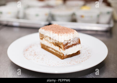 Close-up di tiramisù torta su una piastra bianca. Foto Stock