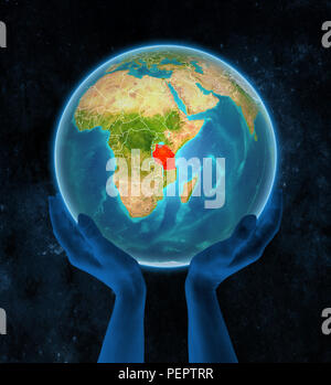 Tanzania sul pianeta Terra con visibili i confini del paese in mani nello spazio. 3D'illustrazione. Foto Stock