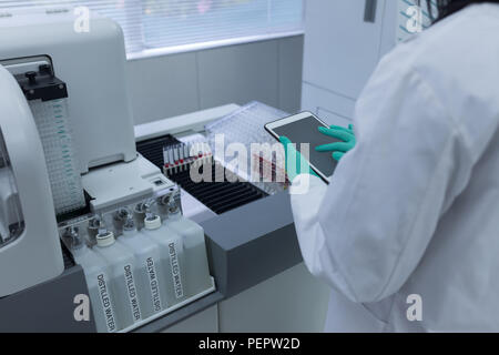 Tecnico di laboratorio utilizzando tavoletta digitale Foto Stock
