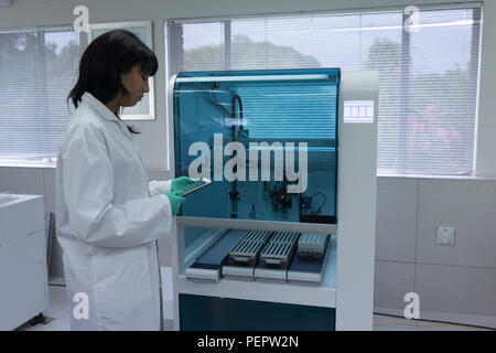 Tecnico di laboratorio utilizzando tavoletta digitale Foto Stock