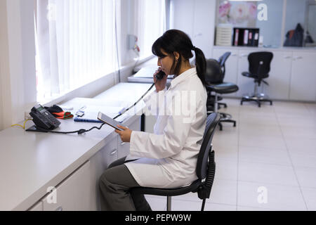 Tecnico di laboratorio parlando al telefono Foto Stock