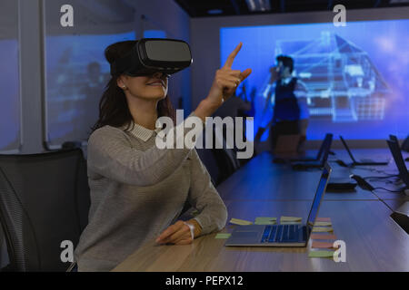 Imprenditrice utilizzando la realtà virtuale auricolare in sala conferenze Foto Stock