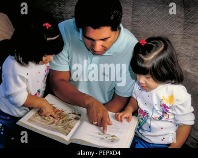 Eredità messicana papà lettura storybook insieme con figlie gemelle sorelle. Signor © Myrleen Pearson ...Ferguson Cate Foto Stock