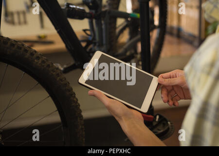 Uomo con tavoletta digitale in officina Foto Stock