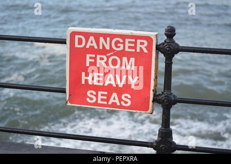 Metallo rosso segno di avvertimento pericolo da pesanti mari a Scarborough lungomare Foto Stock