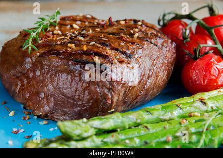 Bistecca di manzo alla griglia con asparagi pomodori spice su piastra Foto Stock