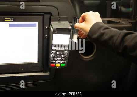 Il passeggero pagando la tariffa del taxi con carta di credito nel lettore di schede. Foto Stock