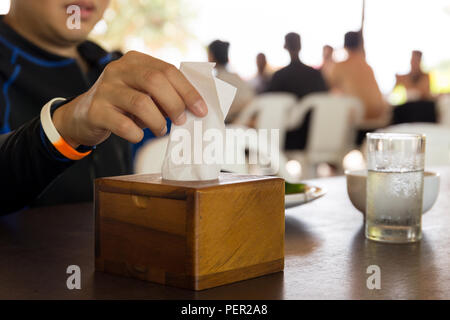Raccolta a mano carta velina bianca dalla casella di tessuto a ora di pranzo. Foto Stock