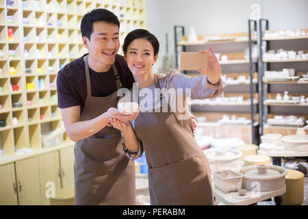 Giovani potters tenendo selfie in studio Foto Stock