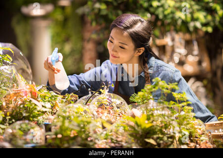 Giovane donna che lavorano nel negozio di vegetali Foto Stock