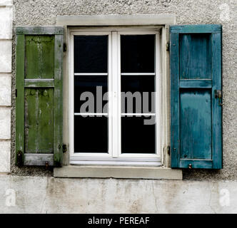 Singola finestra con il vecchio blu e persiane di legno verde Foto Stock