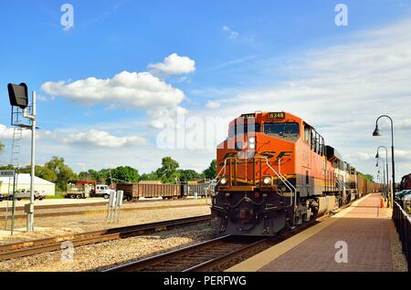 Mendota, Illinois, Stati Uniti d'America. Un easbound Burlington Northern Santa Fe treno di unità del vuoto del carbone vetture rumbling attraverso Mendota sul suo viaggio a Chicago. Foto Stock