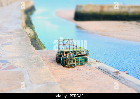 Impilati la pesca di aragoste pentole scatole reticolare a parete del porto Foto Stock