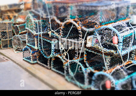 Impilati la pesca di aragoste pentole scatole reticolare a parete del porto Foto Stock